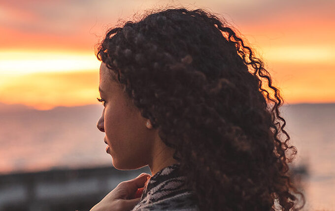 Woman looking out a sunset