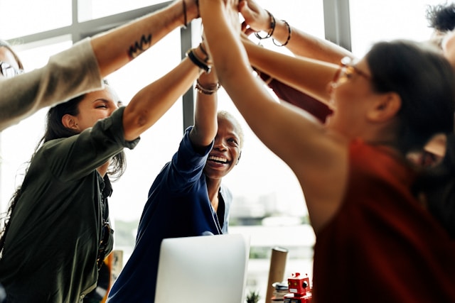People at work high-fiving (Unsplash)