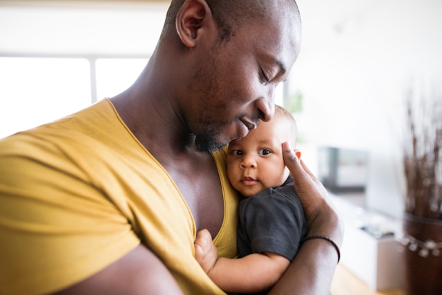 Father holding baby (unsplash)