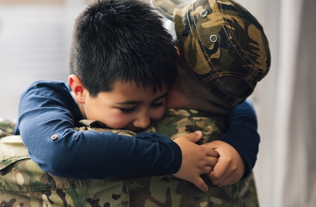 Little boy hugging veteran parent (Unsplash)