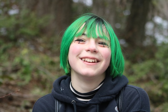 Youth with green hair smiling (Nyx Lilith for Unsplash)