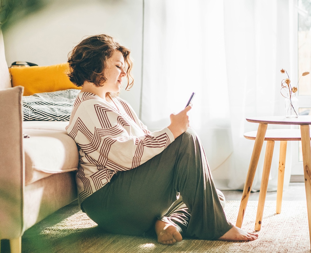Woman sitting on floor with phone