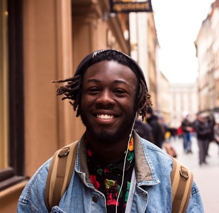Teen guy with backpack smiling (Yingchou Han for Unsplash)