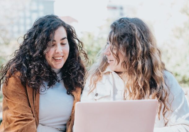 Two women using a laptop outdoors (A.C. for unsplash)
